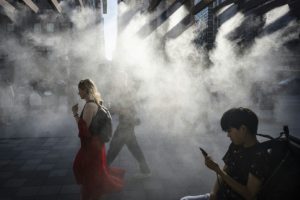 people-walk-under-water-misting-system-cool-down-heat-grips-tokyo.jpg