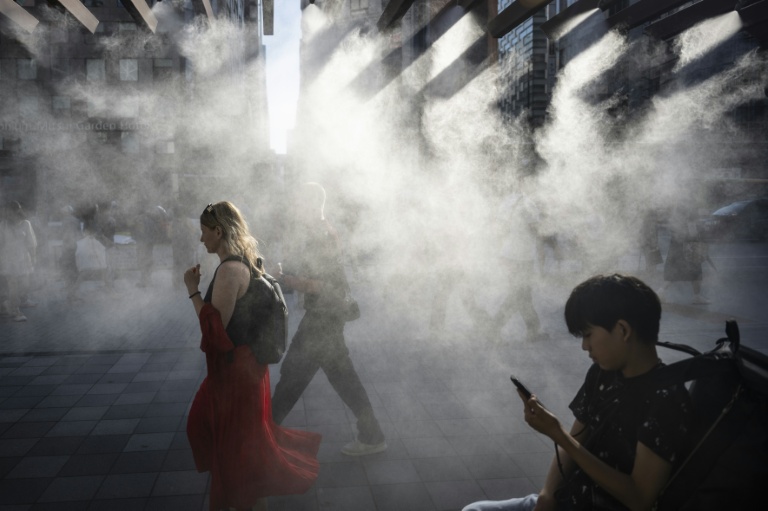 people-walk-under-water-misting-system-cool-down-heat-grips-tokyo.jpg